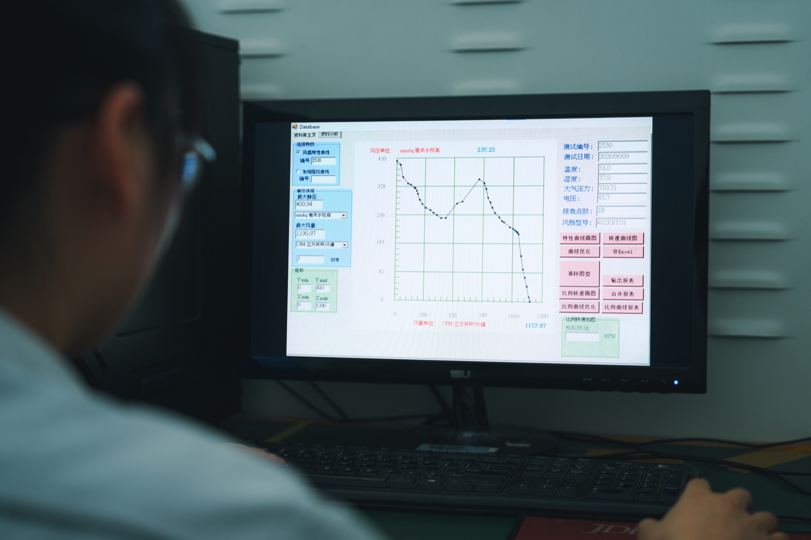 Engineer reviewing fan P-Q curve test data on analysis software showing pressure-flow performance measurements for 28VDC avionics fan evaluation
