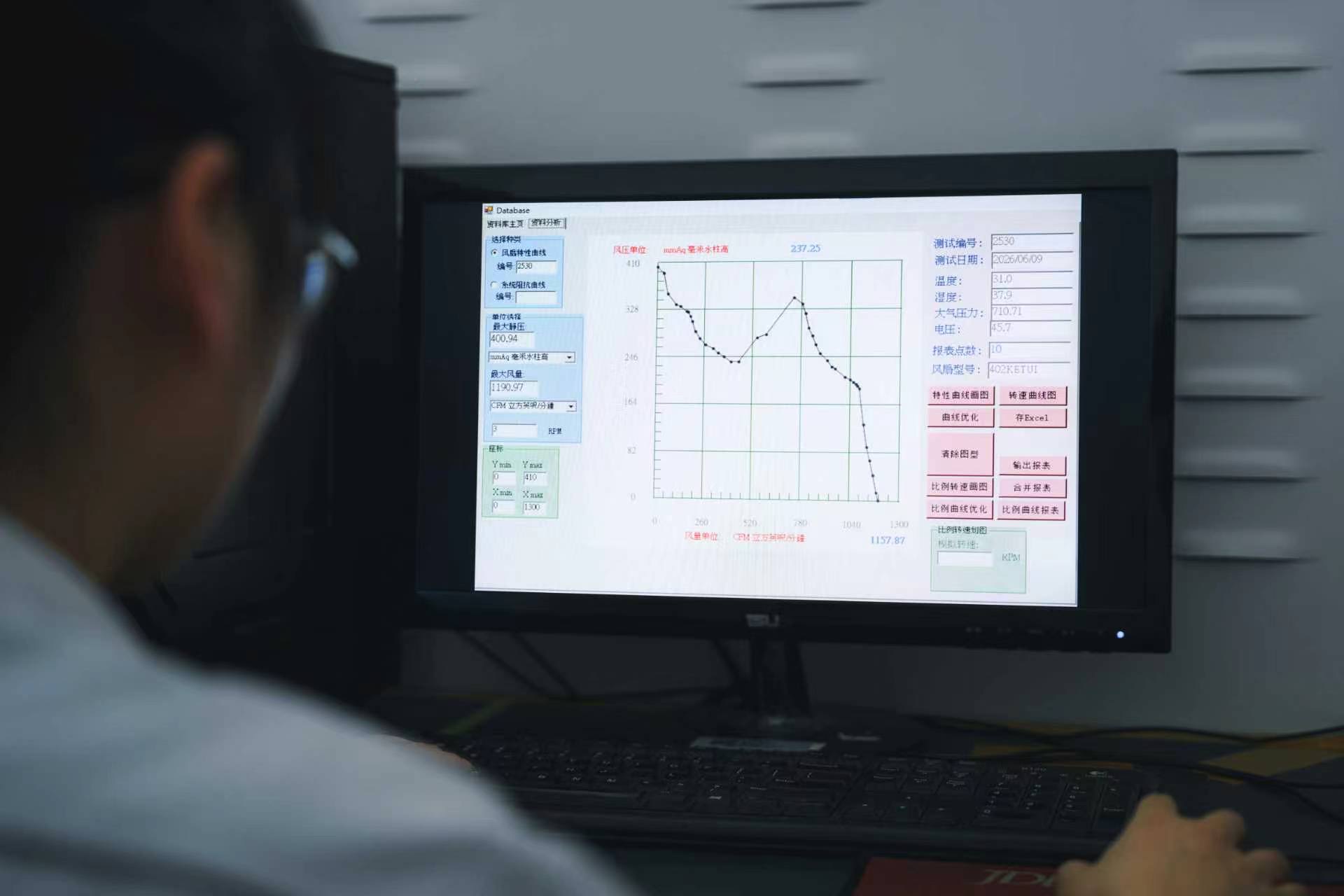 Engineer analyzing fan P-Q curve data on testing software showing pressure-flow performance characteristics